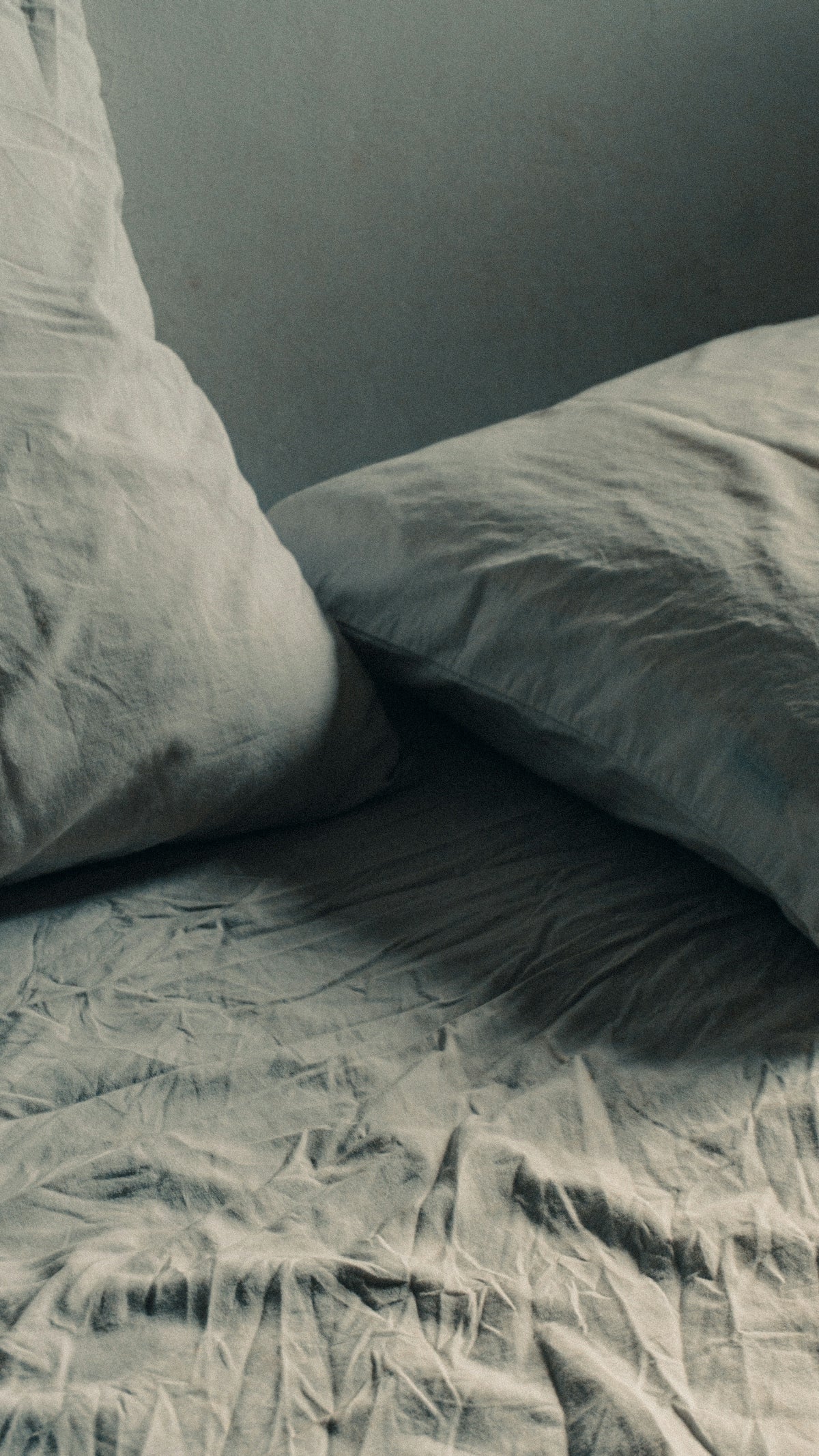 a black and white photo of a bed with two pillows