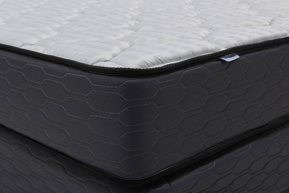 Close-up of a modern mattress with a dark patterned base.