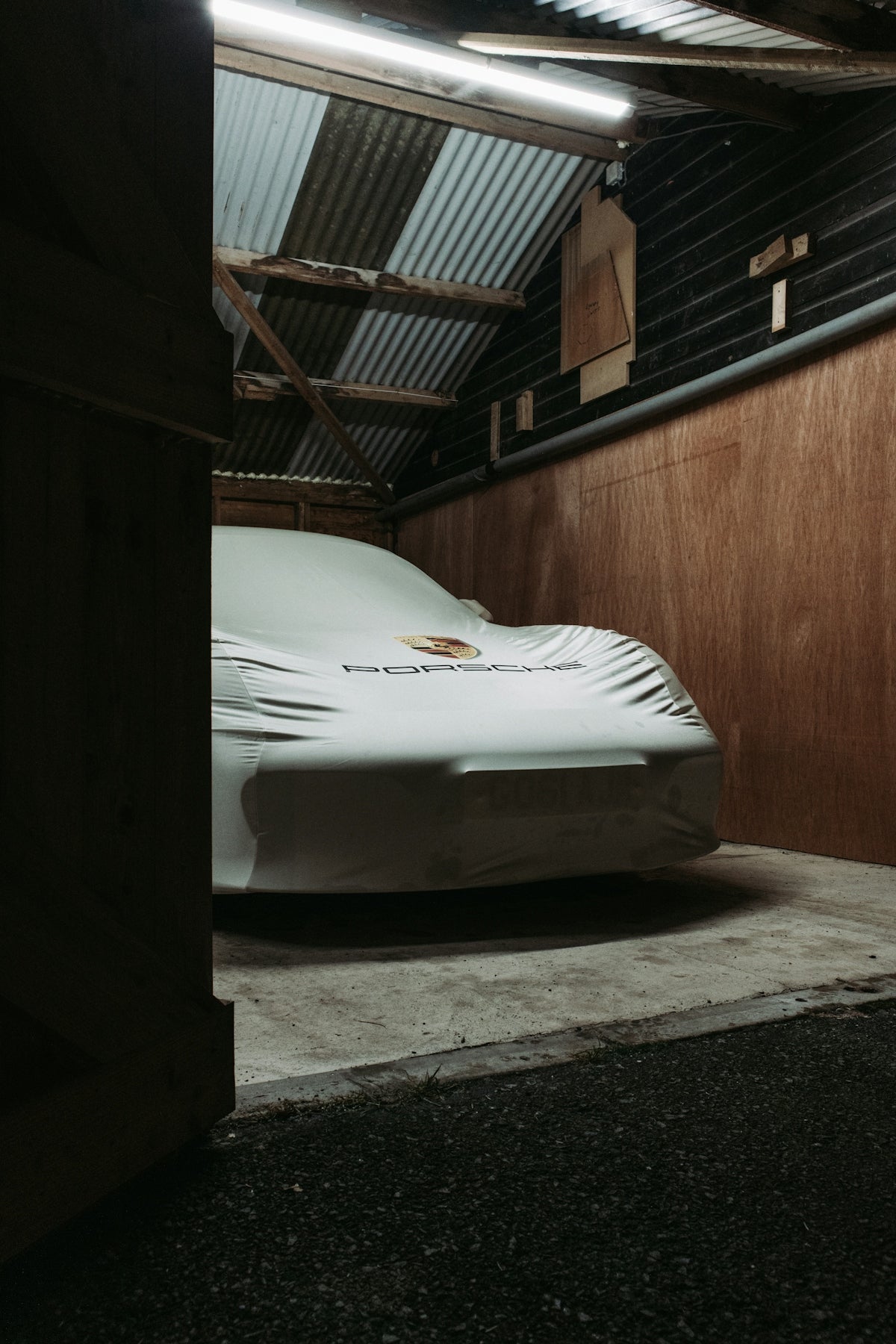 white car parked beside brown wooden wall