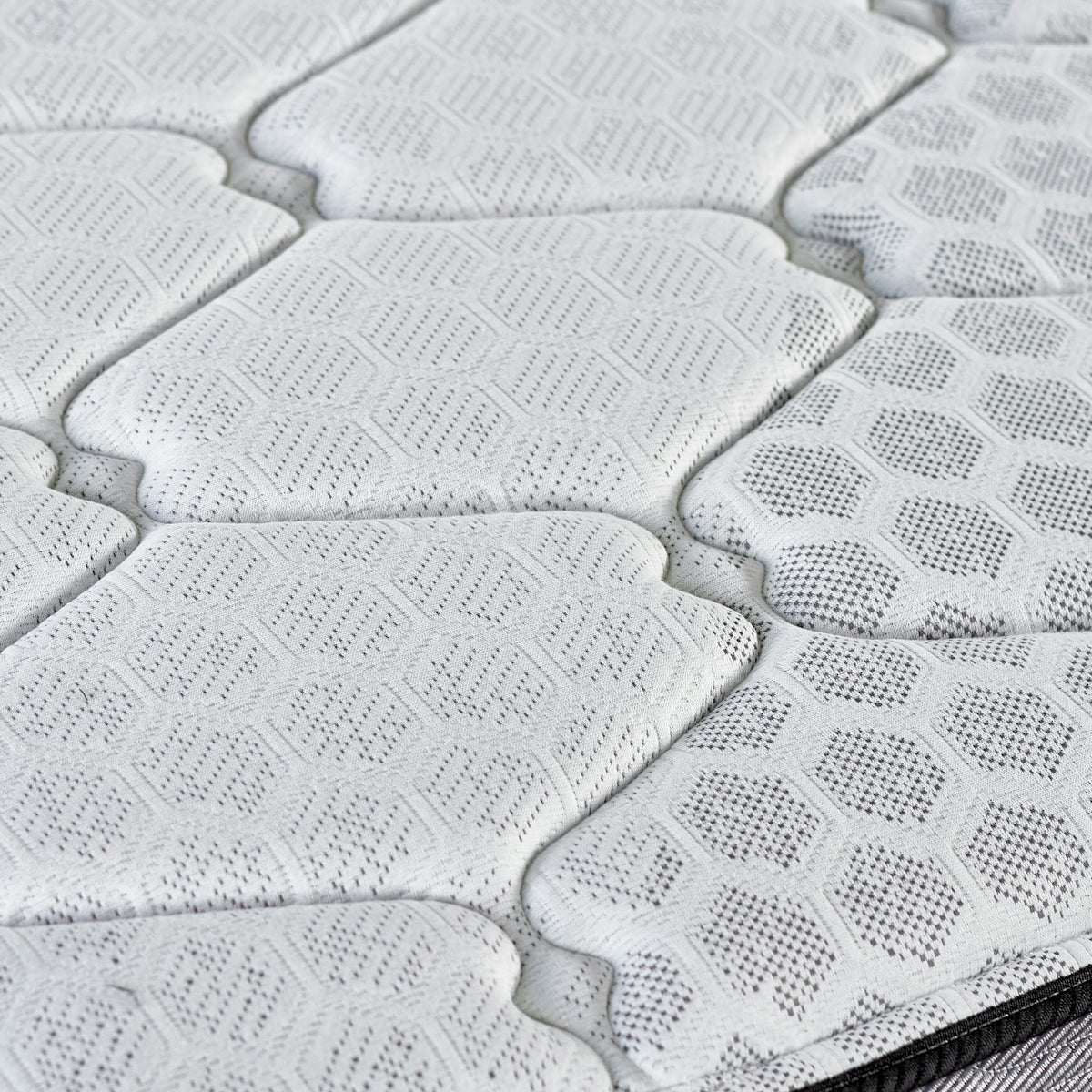 Close-up of a quilted mattress surface with hexagonal pattern.