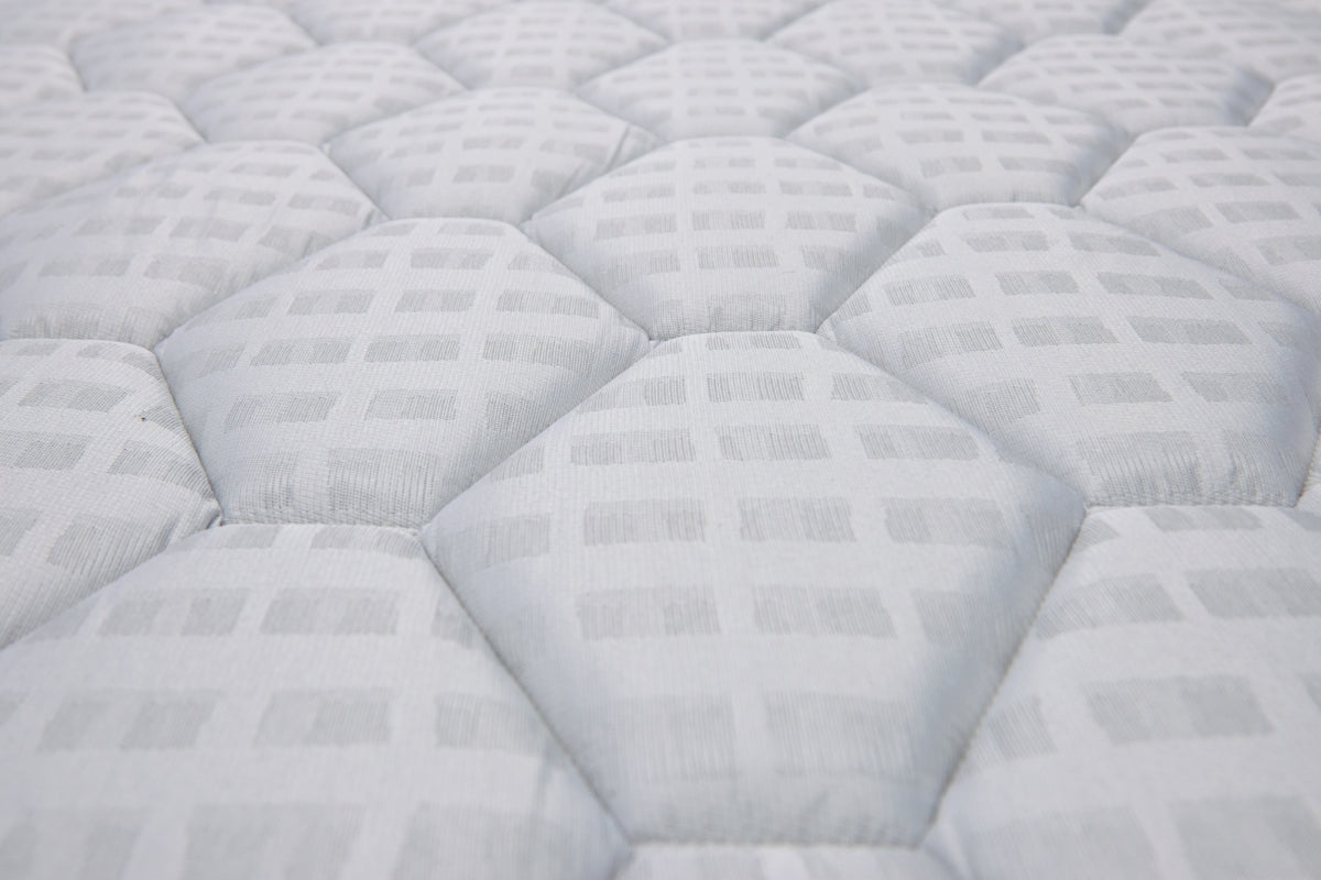 Close-up of a white quilted mattress pattern.