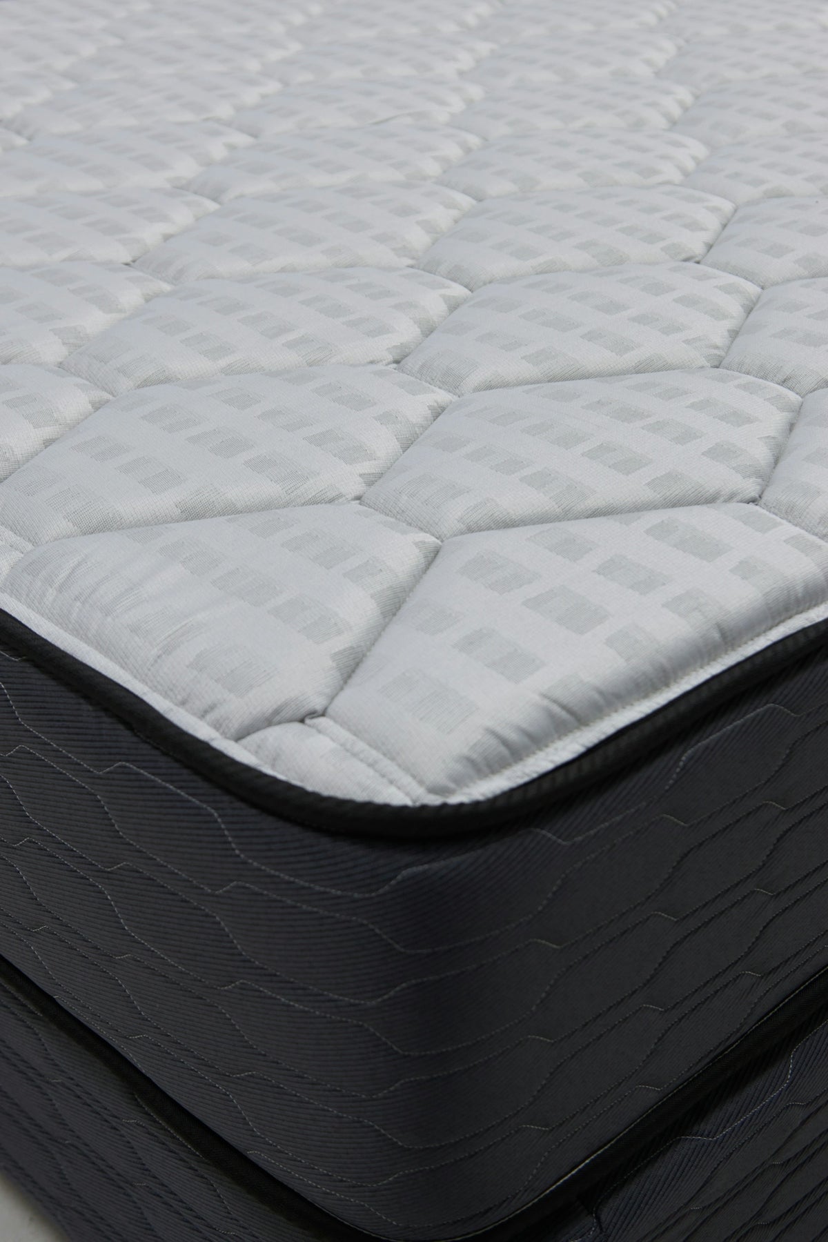 Close-up of a quilted mattress with dark sides.