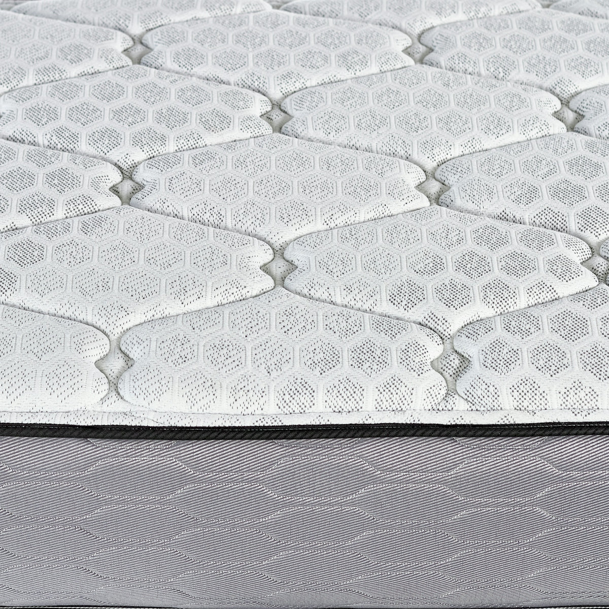 Close-up of a quilted mattress surface with hexagonal pattern.