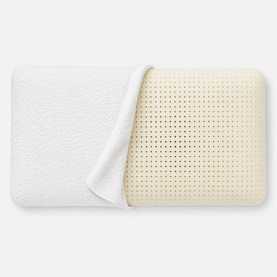 A natural latex pillow with a textured white fitted sheet partially pulled back to reveal the perforated cream-colored inner surface, set against a clean white background.